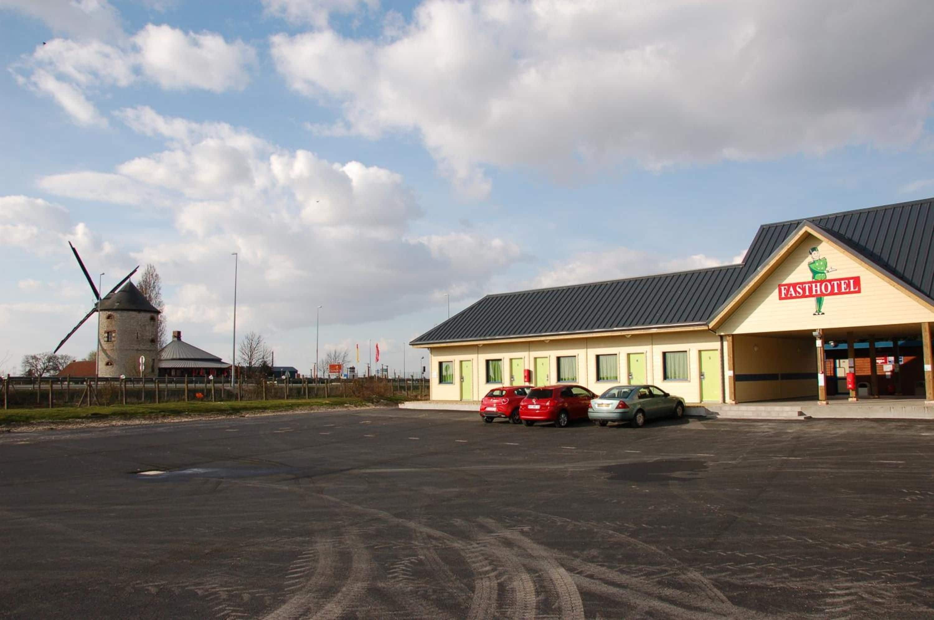 A building with a sign reading 'FASTHOTEL' and a windmill in the background.