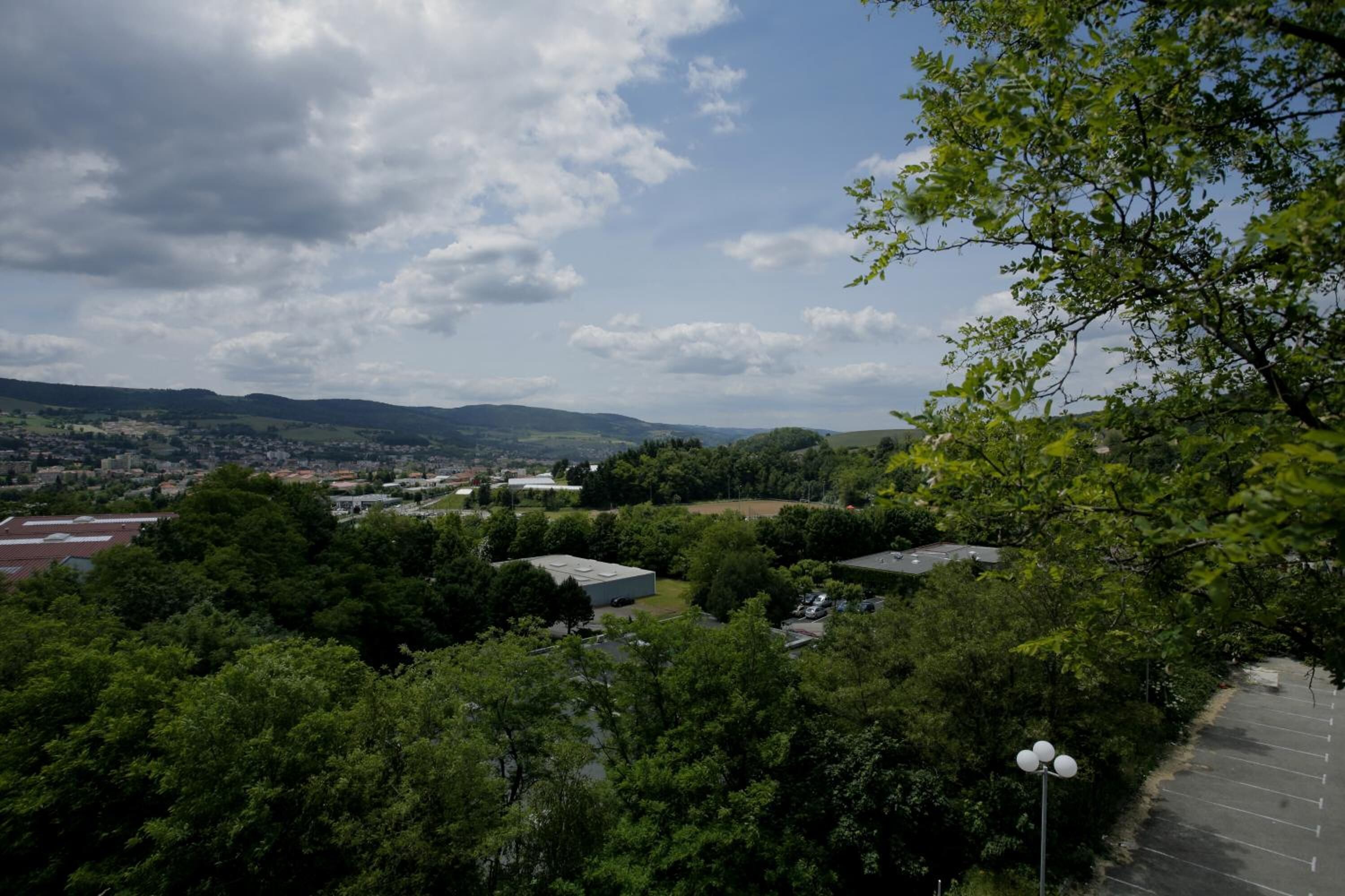A view of a parking area surrounded by trees and buildings.