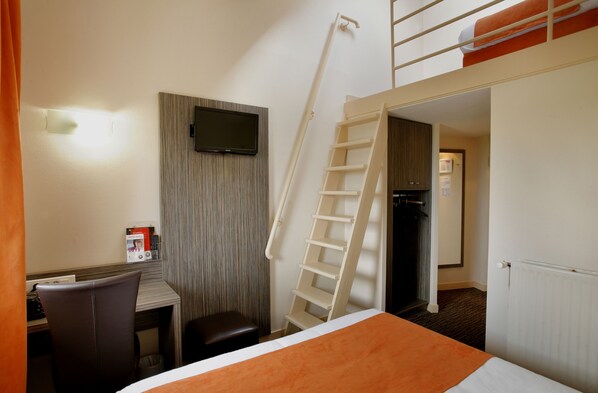 A hotel room with a bed, a desk, a chair, a TV mounted on the wall, a ladder, and a door leading to another room. - The Originals City, Hôtel L'Acropole (La Ricamarie)