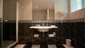 A bathroom with a large mirror, a sink, and a towel rack. - Logis Hôtel les Hauts de St Maure (Sainte-Maure-de-Touraine)