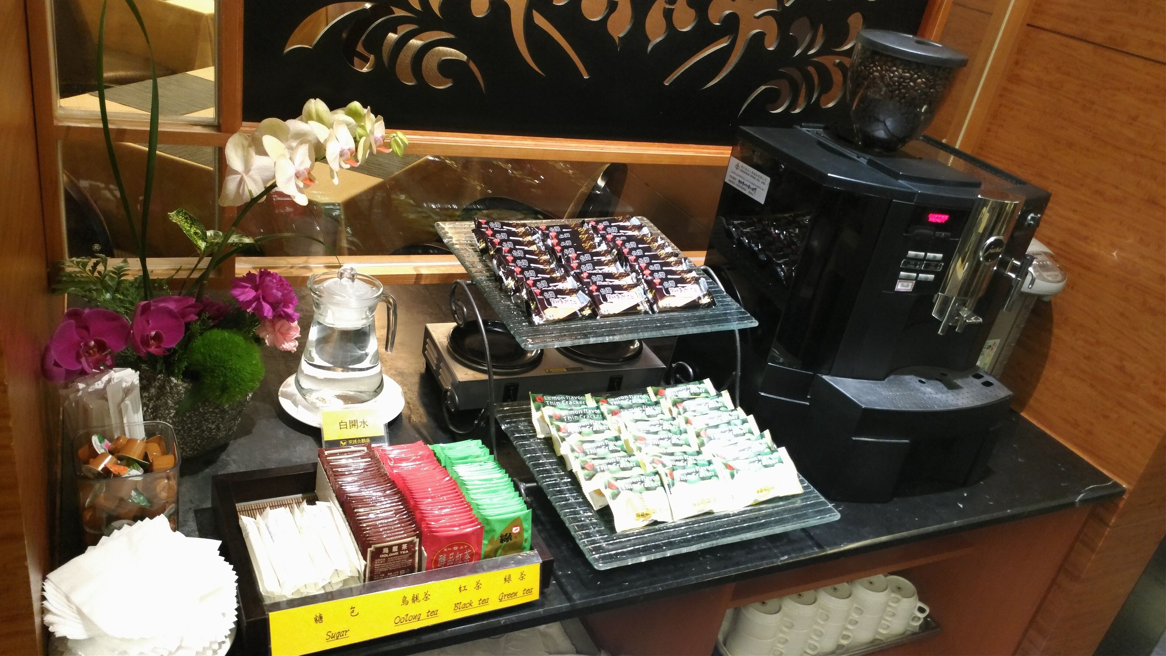 A coffee station with various tea and coffee options, including a coffee machine and a tea dispenser.