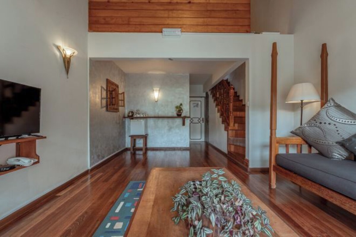 Un vaste espace de vie doté d’un plancher en bois, d’un canapé, d’une table basse et d’un téléviseur.
