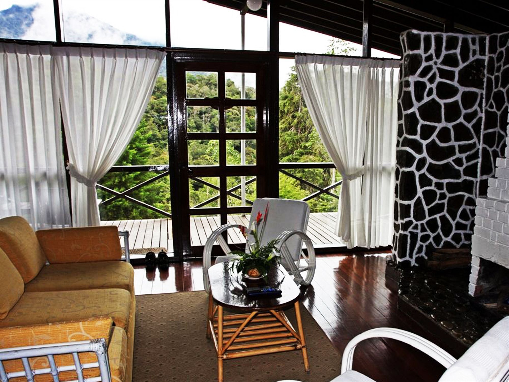 A cozy room with a sofa, a dining table with chairs, and a fireplace.