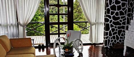 A cozy room with a sofa, a dining table with chairs, and a fireplace.