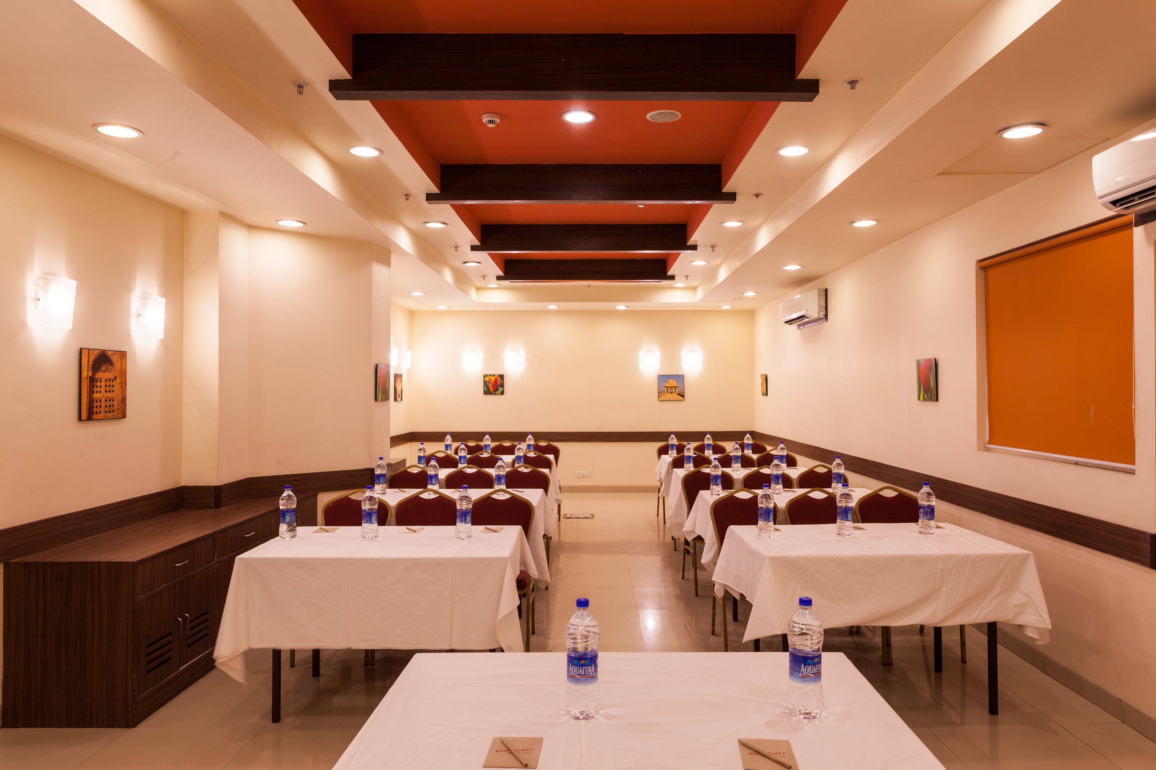 A conference room with multiple tables, each with water bottles and nameplates.