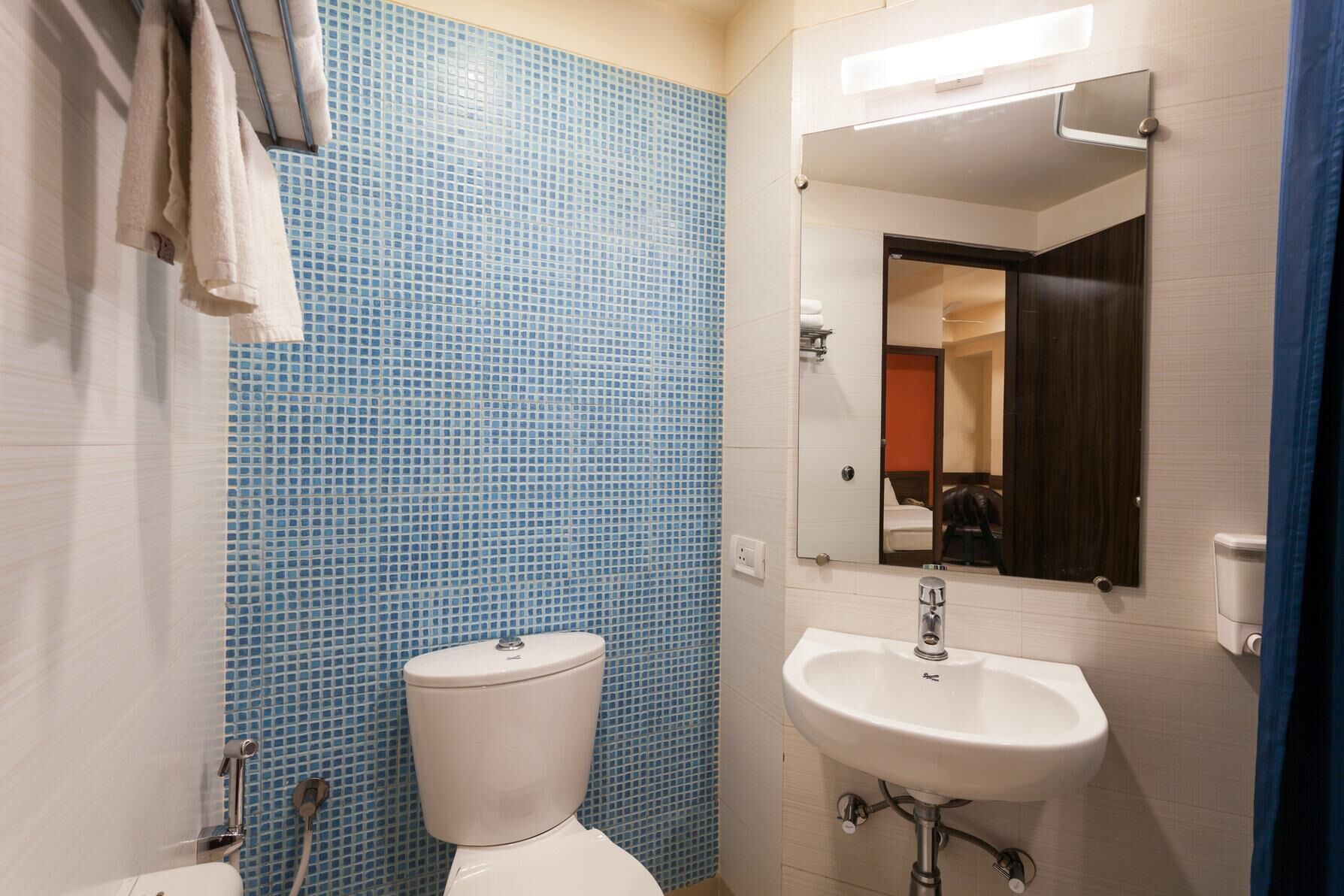 Une salle de bain avec des toilettes, un lavabo et un miroir.