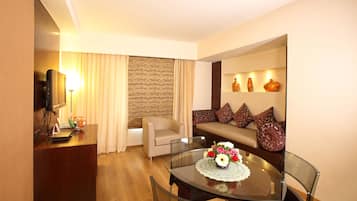 Suite, 1 King Bed | Living area | 32-inch LCD TV with satellite channels, TV