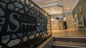 A reception area with a decorative metal partition displaying the name 'SARNIC'. - Sarnic Premier Hotel - Special Class (Istanbul)