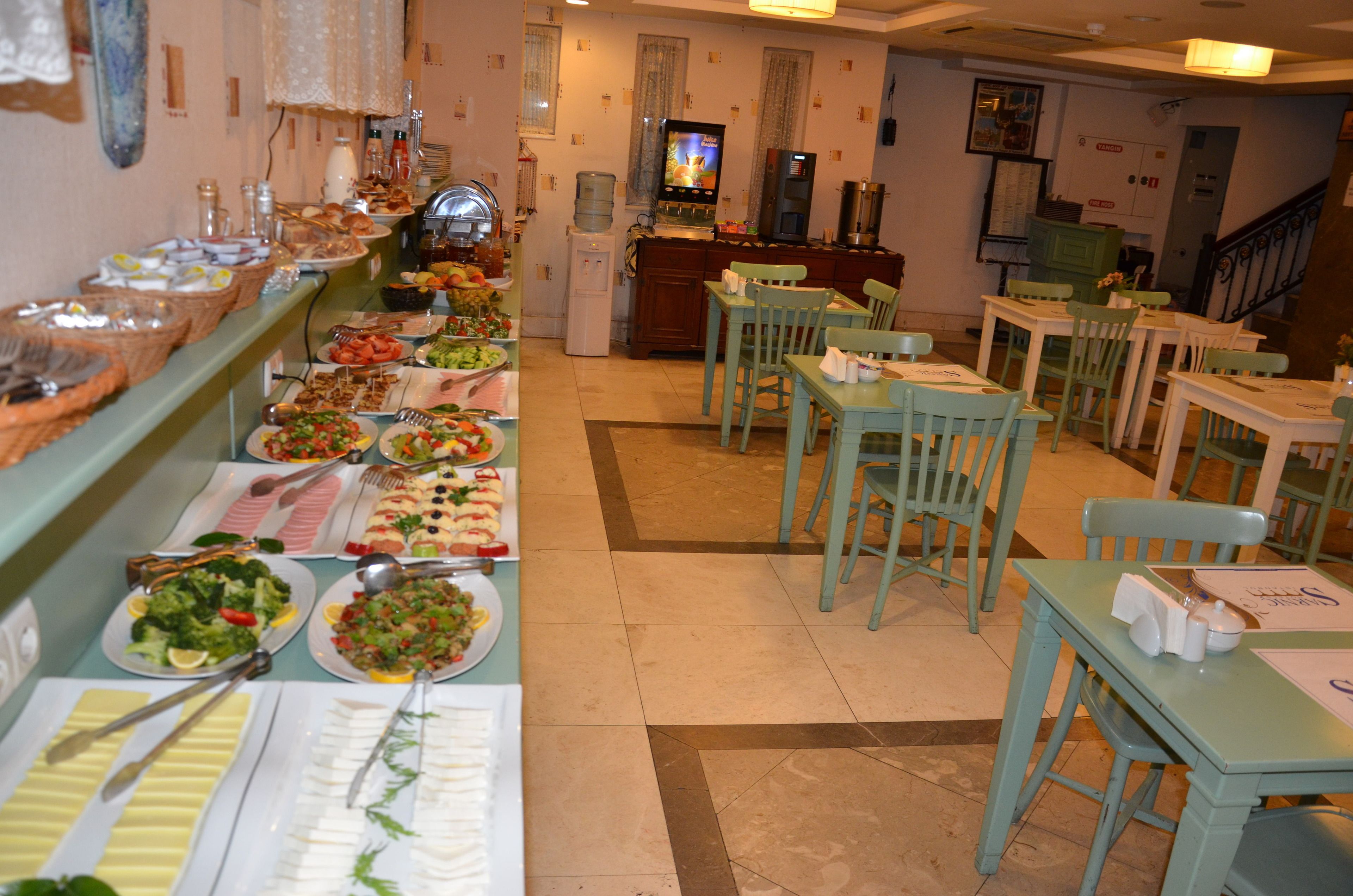 A buffet area with various food items and a television in the background.