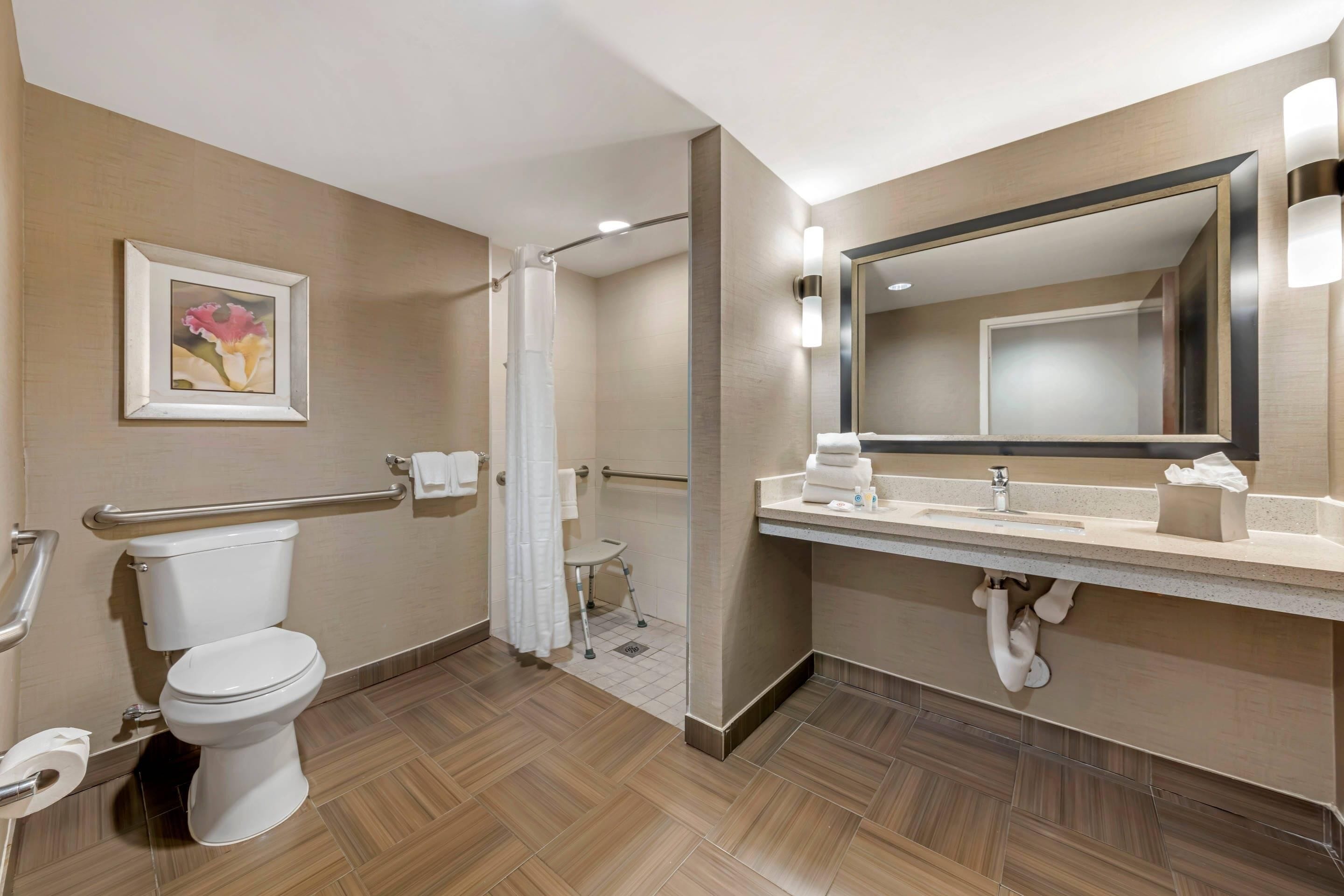 Een moderne badkamer met toilet, wastafel en douche.