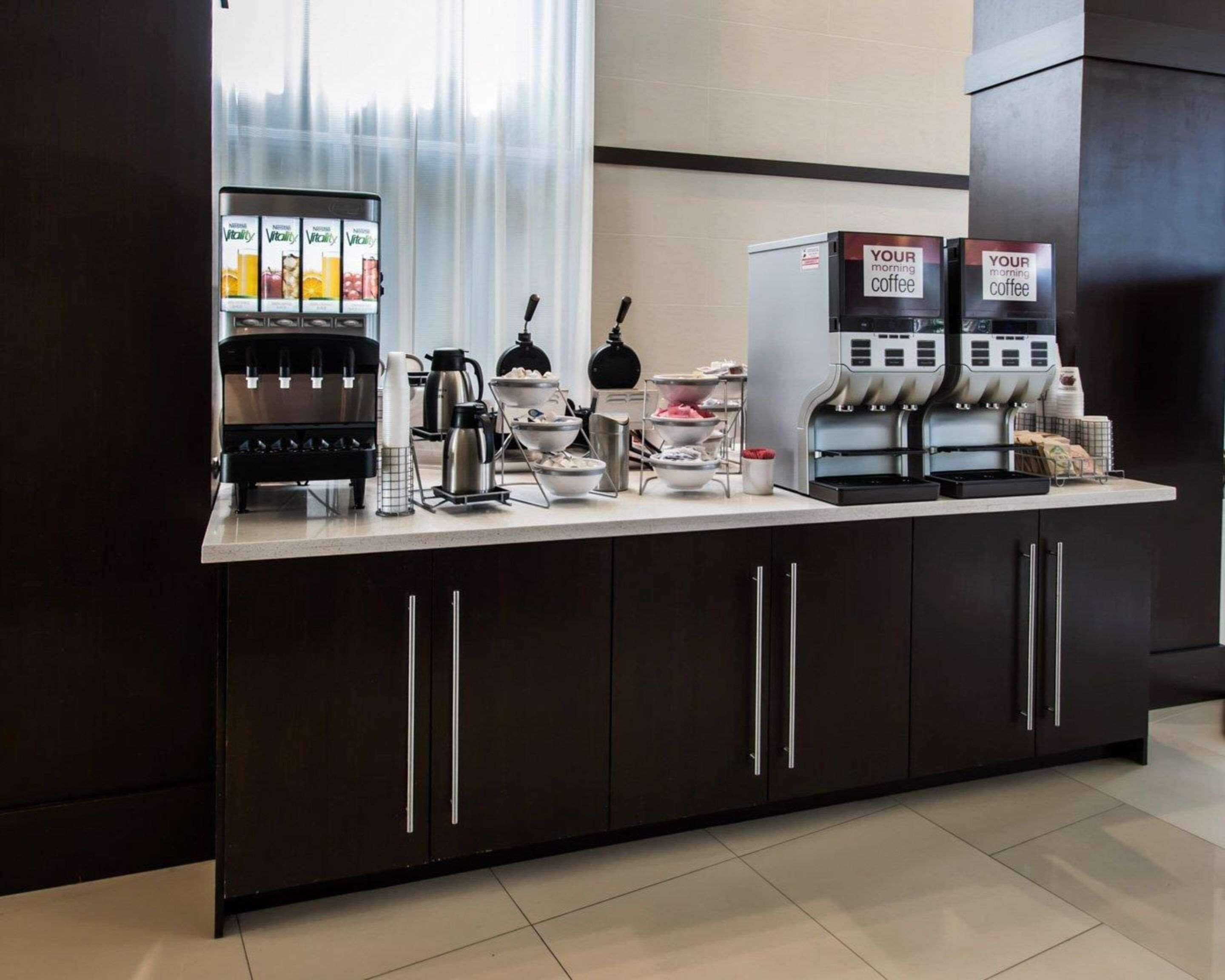 A modern coffee station with multiple coffee dispensers, a kettle, and various coffee-making equipment.