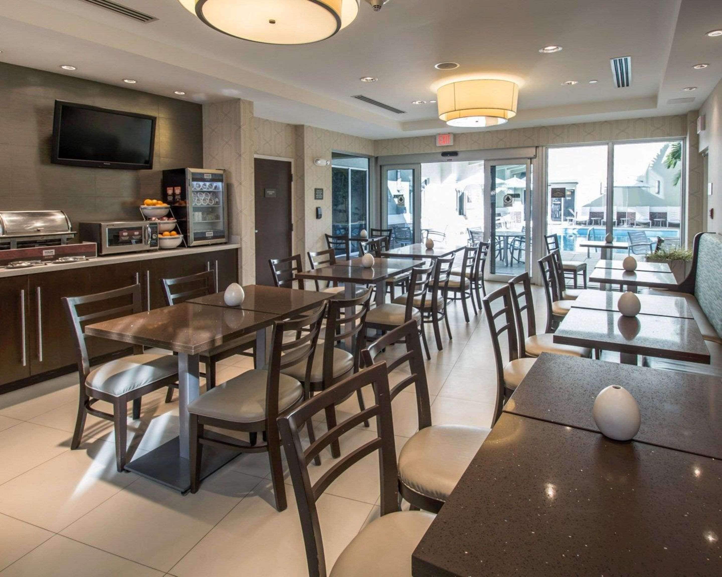 Un restaurante moderno con barra, asientos y vistas al exterior.