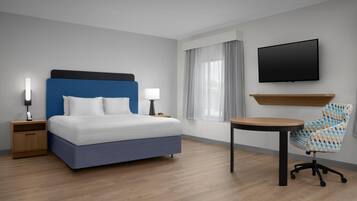 Une chambre d’hôtel avec un lit, des tables de chevet, une télévision, une chaise et une fenêtre avec des rideaux.