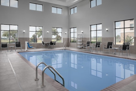 Una piscina techada, sillones reclinables de piscina