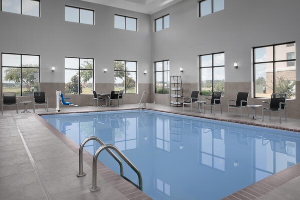 Una piscina techada, sillones reclinables de piscina