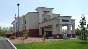 A Hampton Inn hotel with a two-story structure, a covered entrance, and an American flag. - Hampton Inn Geneseo (Geneseo)