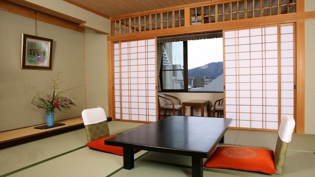 A traditional Japanese room with tatami flooring, a low table, and shoji screens. - Ishicho (Kyoto)