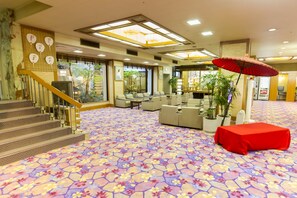 A hotel lobby with a patterned carpet, seating area, and a staircase. - Ishicho (Kyoto)