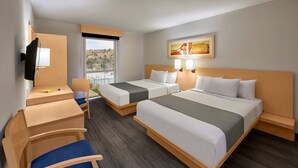 Une chambre d’hôtel avec deux lits, un bureau, une chaise et un téléviseur.