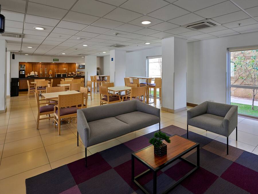 Un espacio interior amplio con zona de comedor, sofás y una mesa de centro.