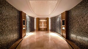 A long, well-lit hallway with textured walls and a polished floor, leading to a distant elevator. - Sheraton Xi'an North City Hotel (Xi'an)