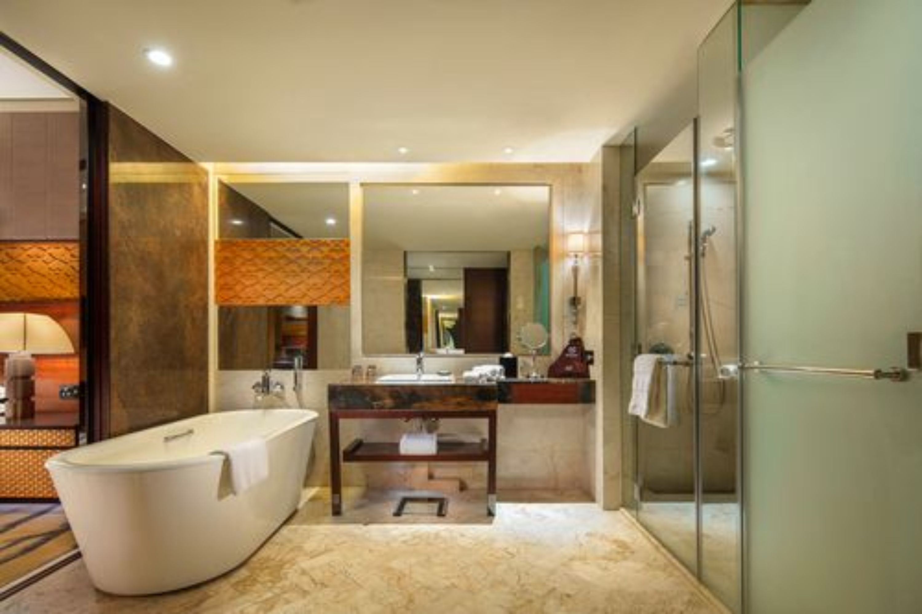 A modern bathroom with a freestanding bathtub, a vanity with a mirror, and a glass-enclosed shower.