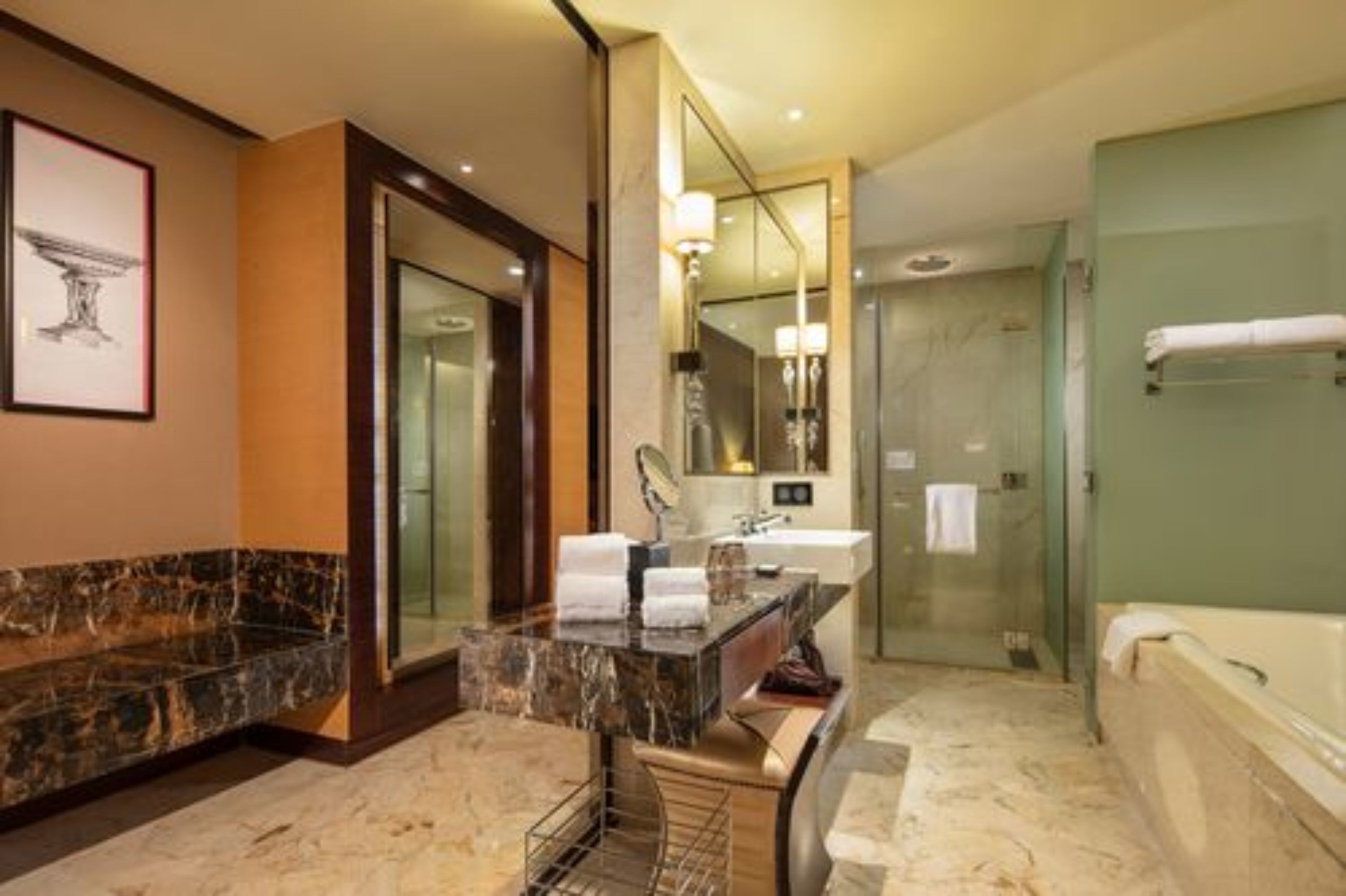 Un baño moderno con tocador de mármol, un espejo grande, cabina de ducha de vidrio y bañera independiente.