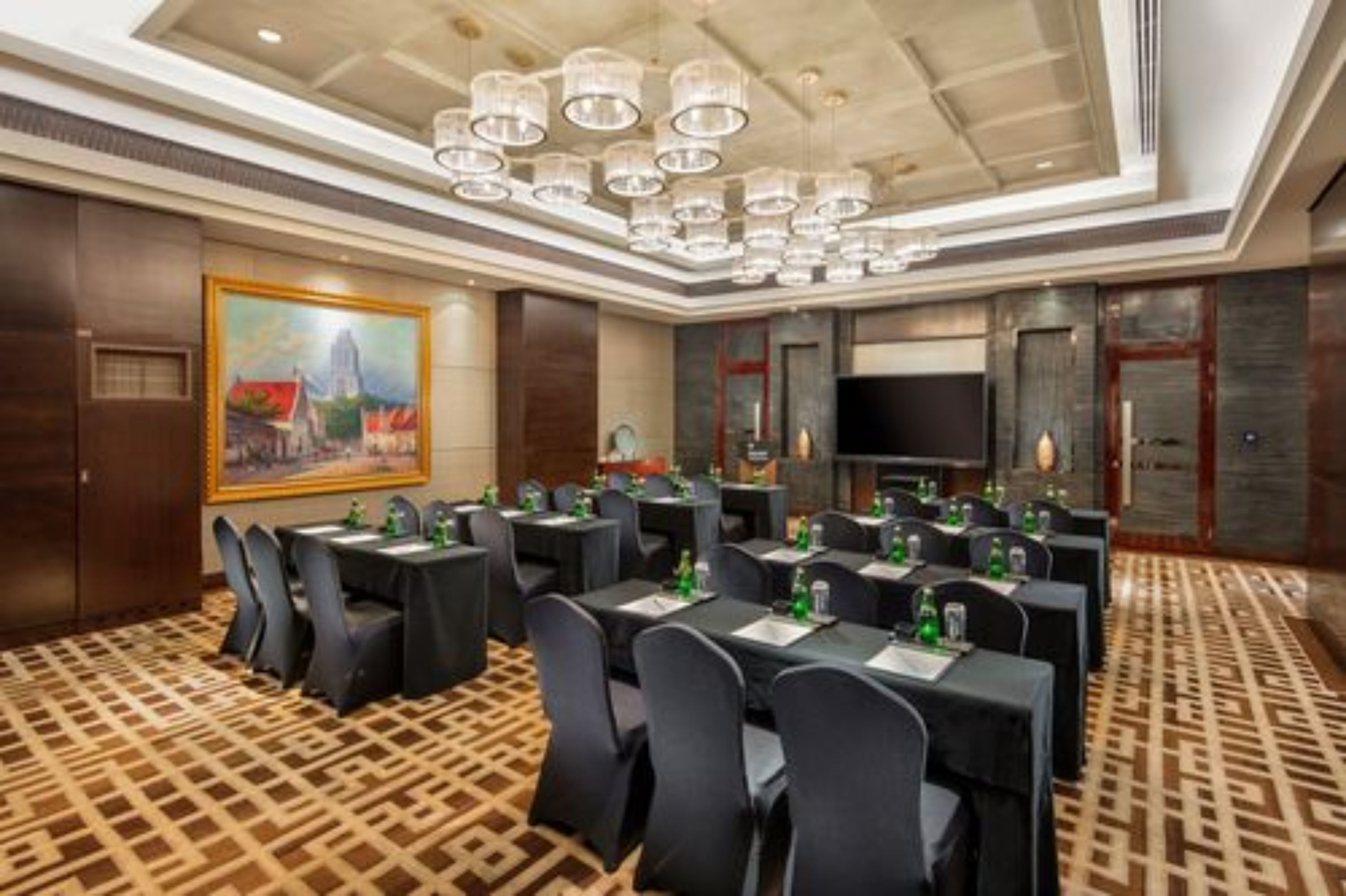 A conference room with multiple tables, chairs, and a large painting on the wall.