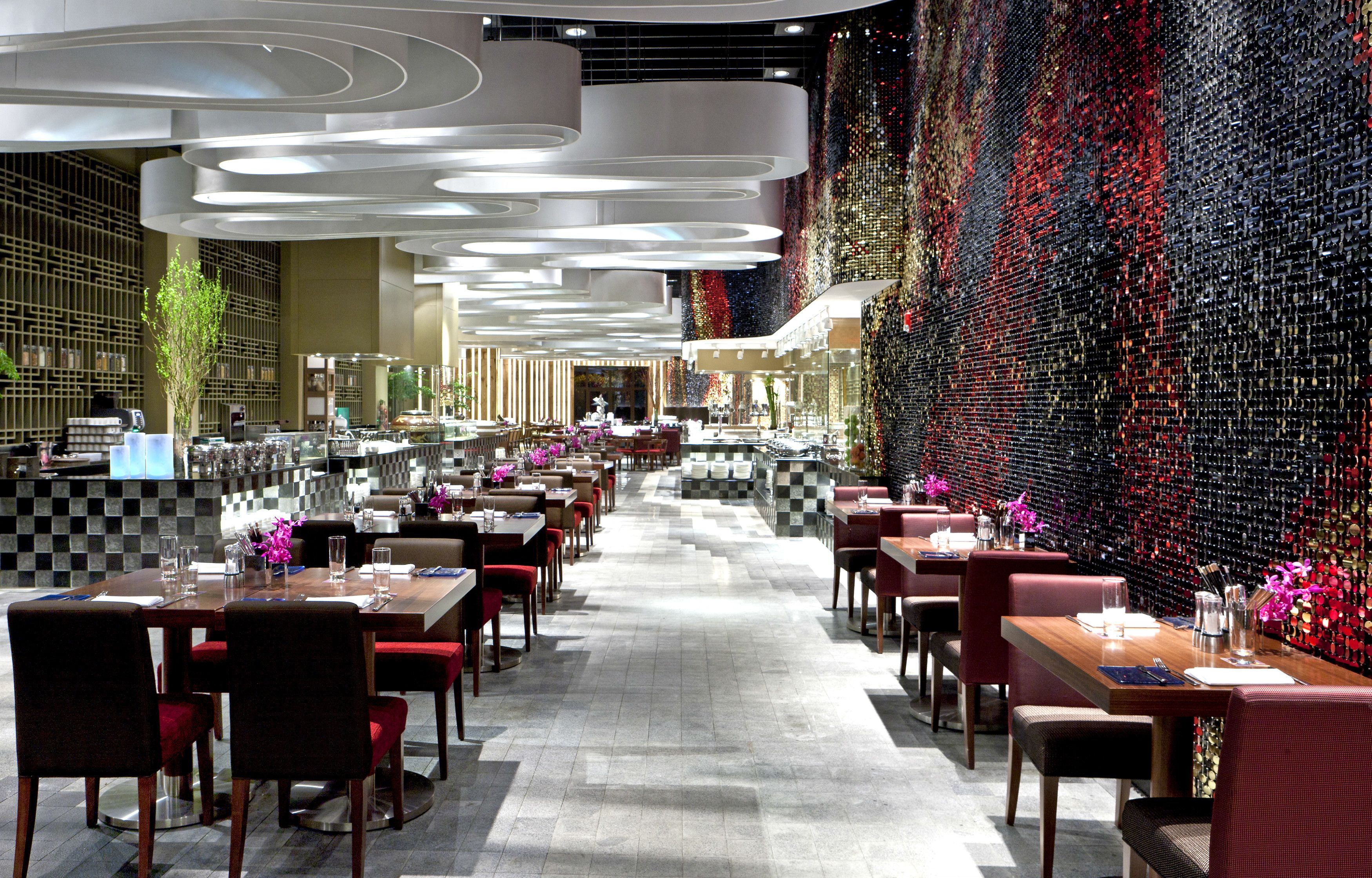 Un restaurant moderne doté d’un long comptoir, de nombreuses tables et de chaises.