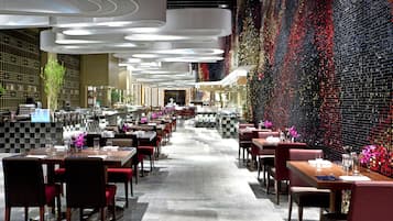 Un restaurant moderne doté d’un long comptoir, de nombreuses tables et de chaises.