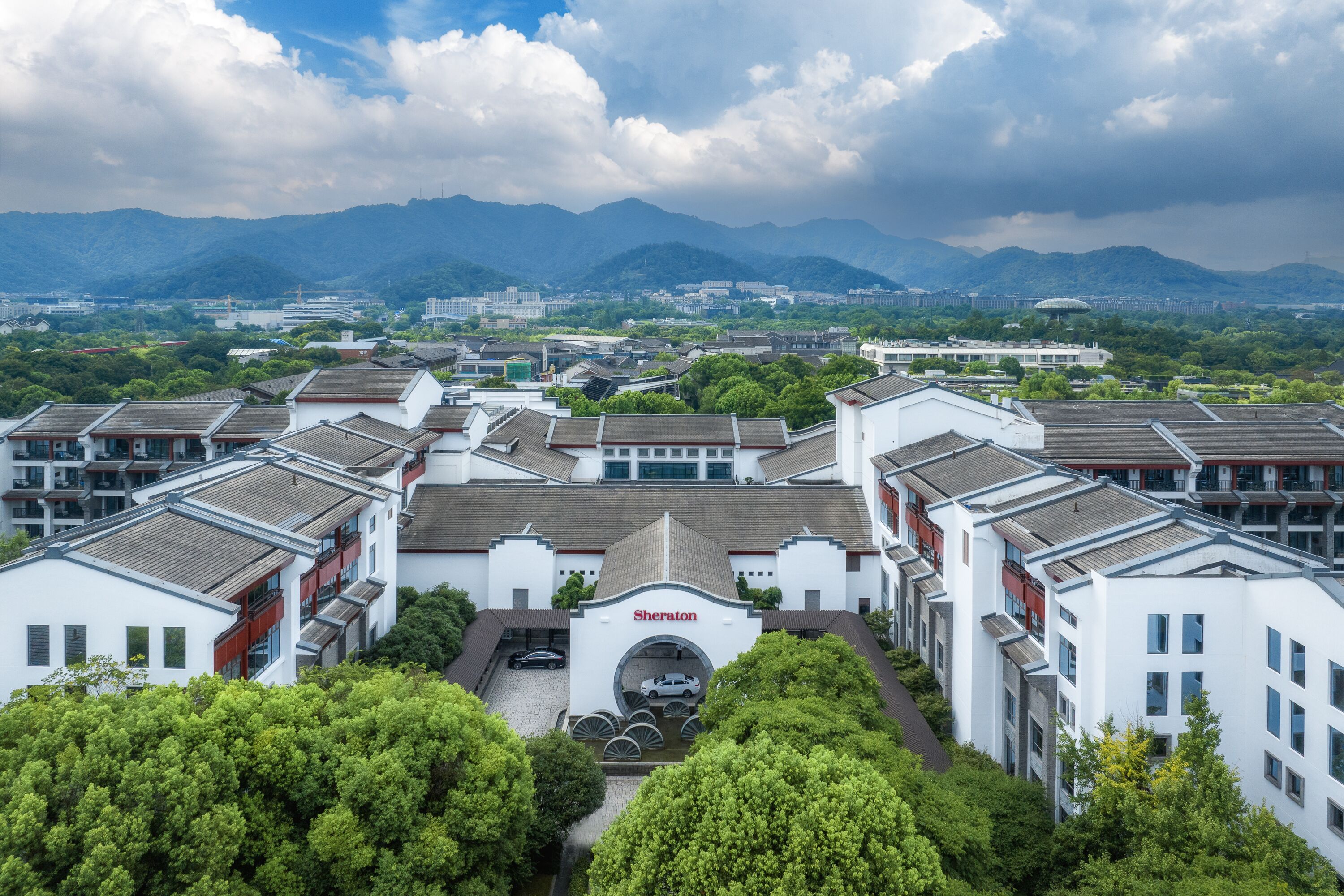 A Sheraton hotel with a traditional architectural style, featuring multiple buildings with flat roofs and a central entrance.