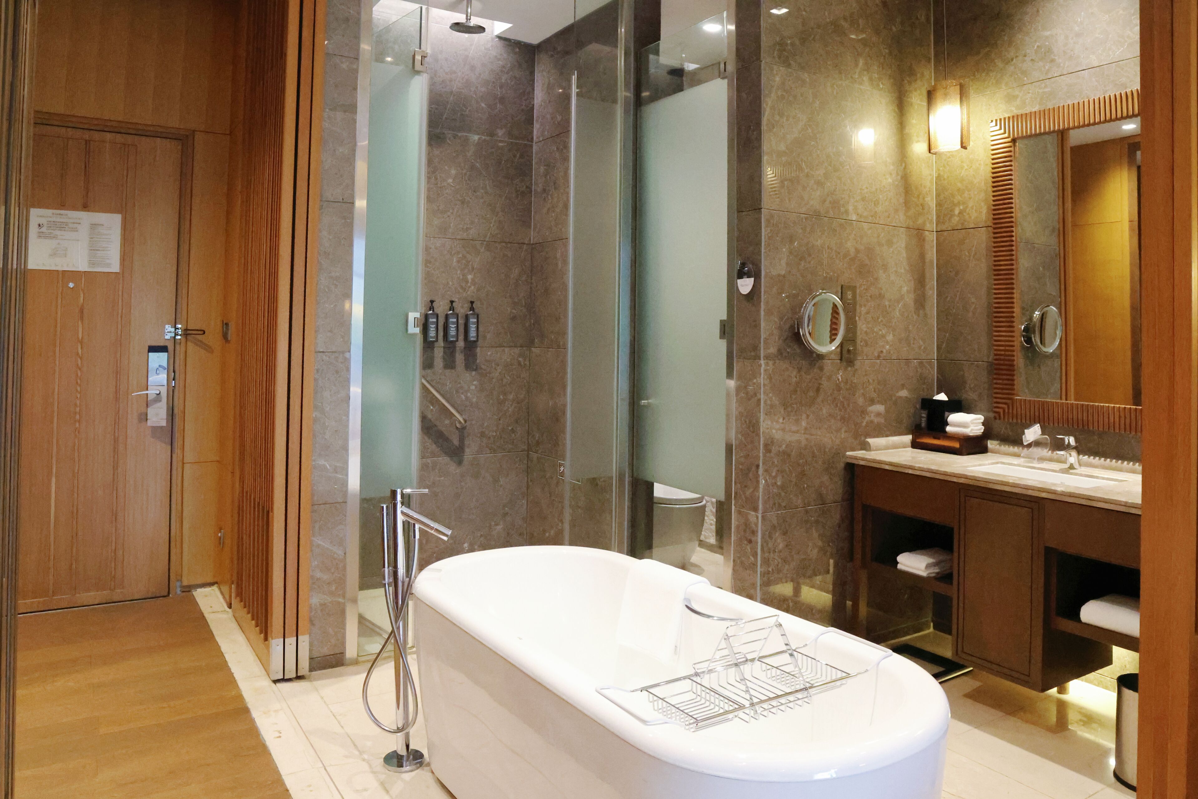 A modern bathroom with a freestanding bathtub, a glass shower enclosure, and a vanity with a mirror.