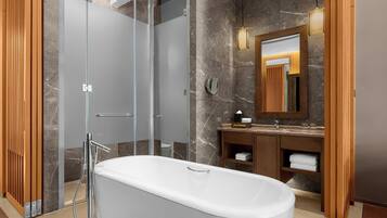 Un bagno moderno con cabina doccia in vetro, vasca freestanding e mobile bagno in legno con specchio.