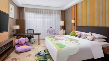 Una habitación de hotel con cama, escritorio, silla, televisor y ventana con cortinas.