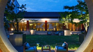 A modern building with a traditional roof, a well-maintained lawn, outdoor seating, and large windows. - Sheraton Grand Hangzhou Wetland Park Resort (Hangzhou)