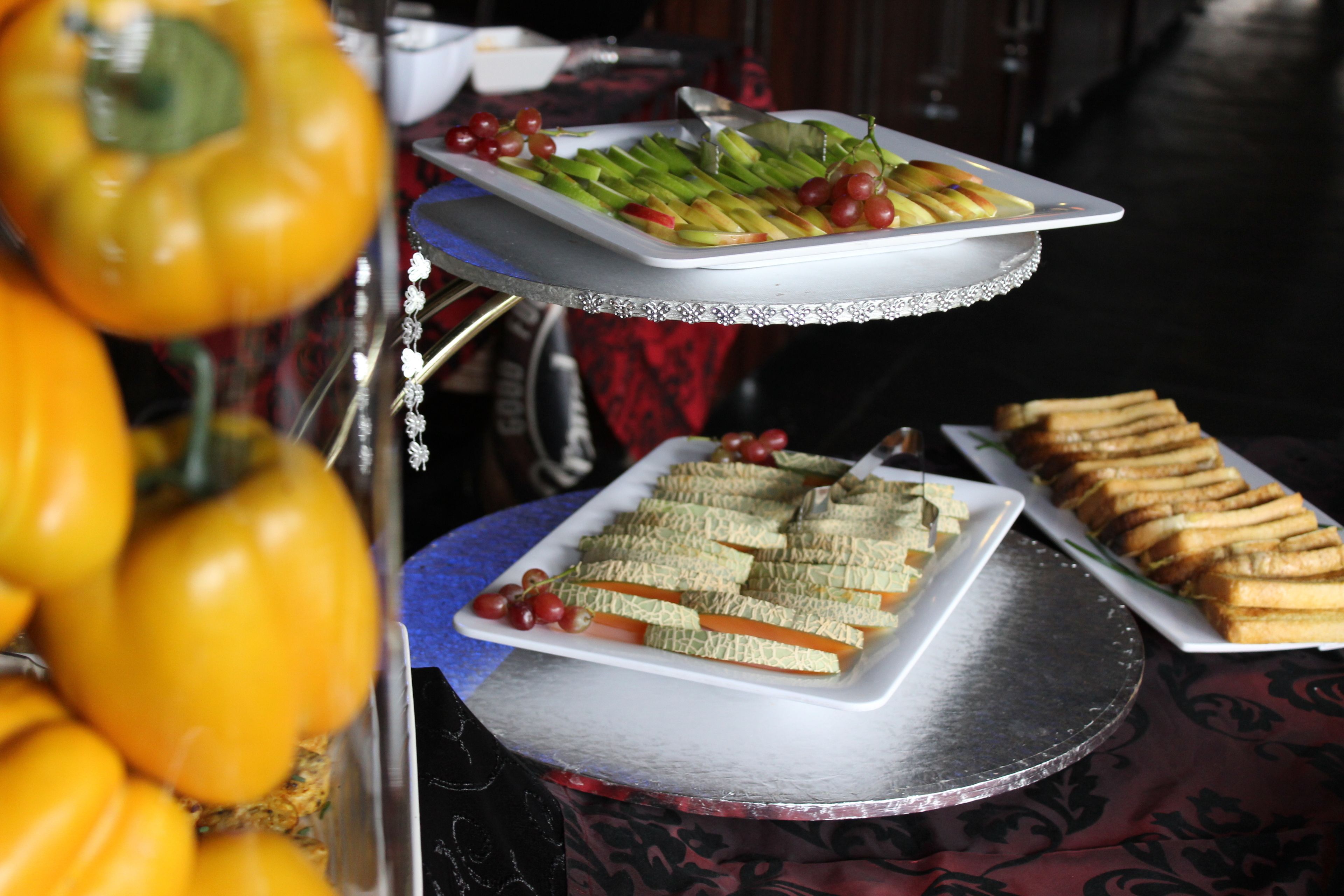 A buffet table with various food items including sandwiches, fruits, and vegetables.