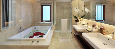 Ein modernes Badezimmer mit einer großen Badewanne, zwei Waschbecken und einer Duschkabine.