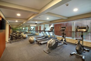 A gym with treadmills, elliptical machines, and free weights.