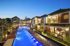 Un hôtel moderne doté d’une piscine, de nombreuses chambres et d’un espace extérieur bien éclairé.