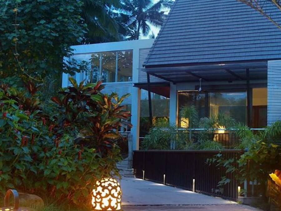 Une maison moderne dotée de grandes fenêtres et d’un porche abrité.