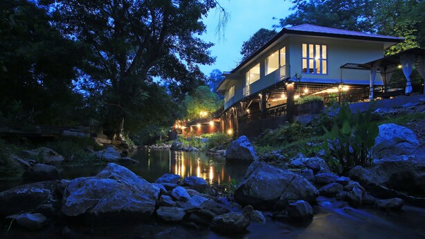 A house with a river in front, large rocks, and trees. - Zantiis Ndol Villas (Muak Lek)