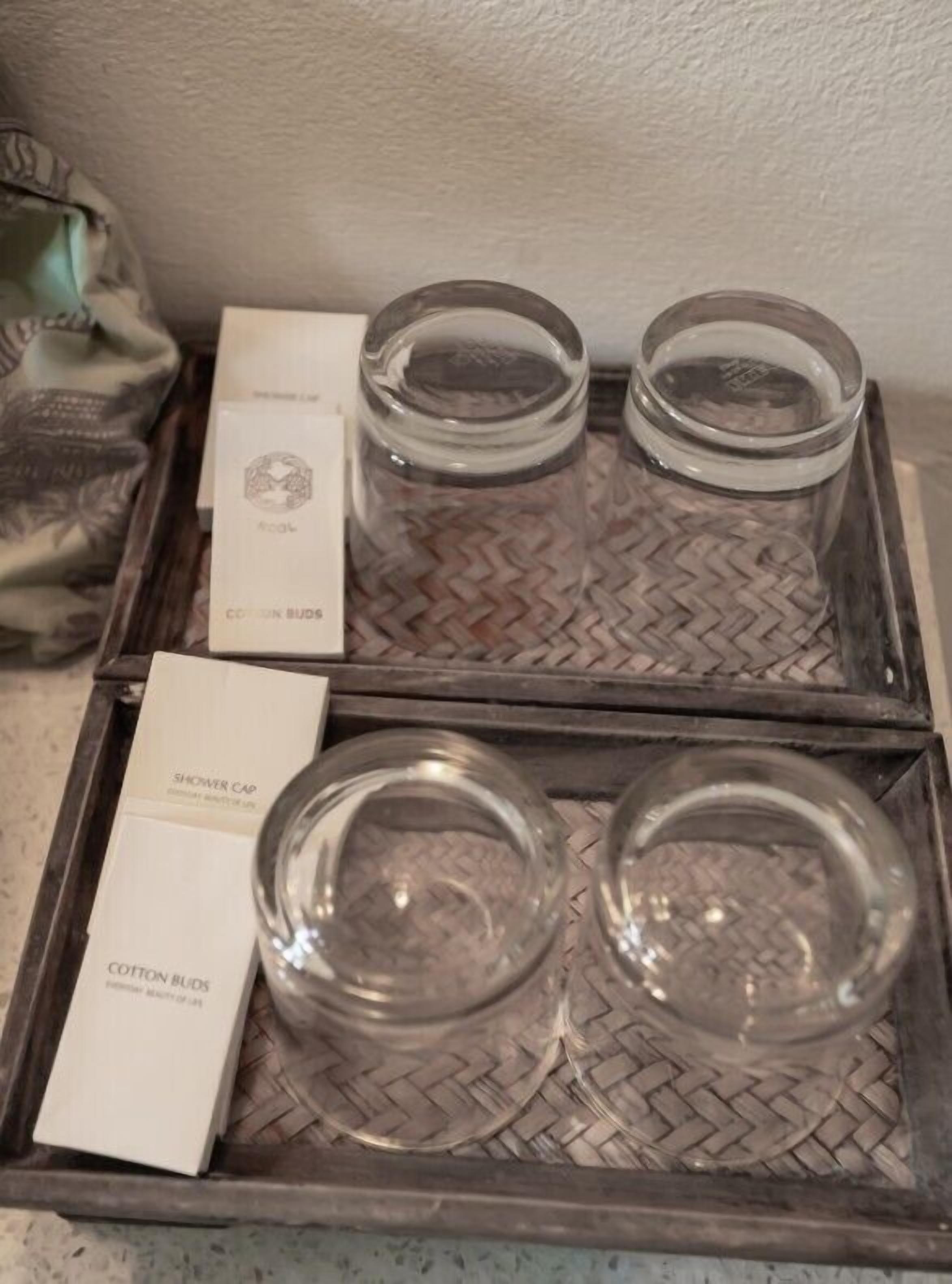 A tray with two glass jars and two boxes labeled "Cotton Buds" and "Shower Cap".