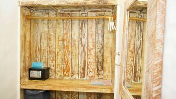 A rustic wooden room with a wooden shelf, a small radio, and a trash bag.