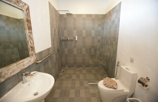 Casa de banho com lavatório, sanita e zona de duche.