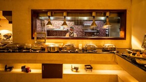 Una barra de buffet con varios recipientes de comida y utensilios.