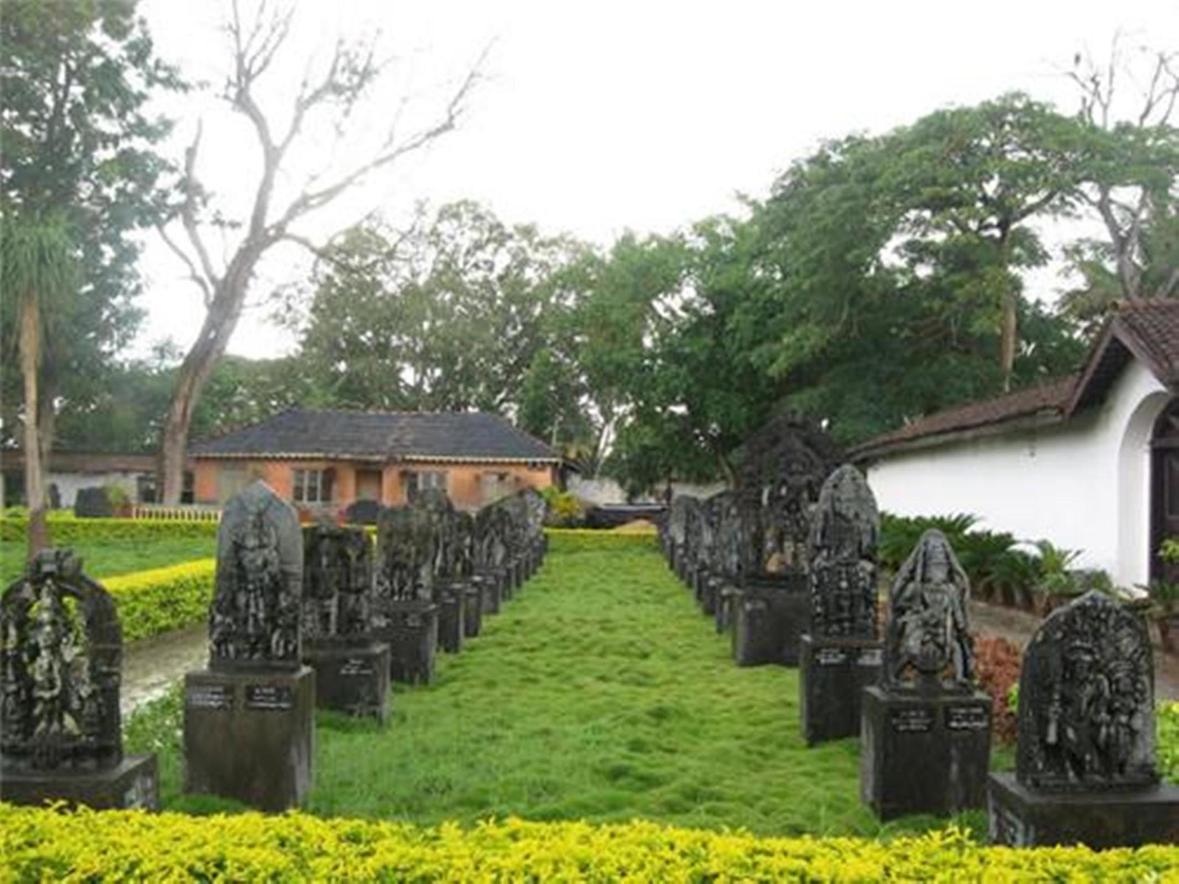 Un cementerio con hileras de lápidas y un edificio blanco al fondo.