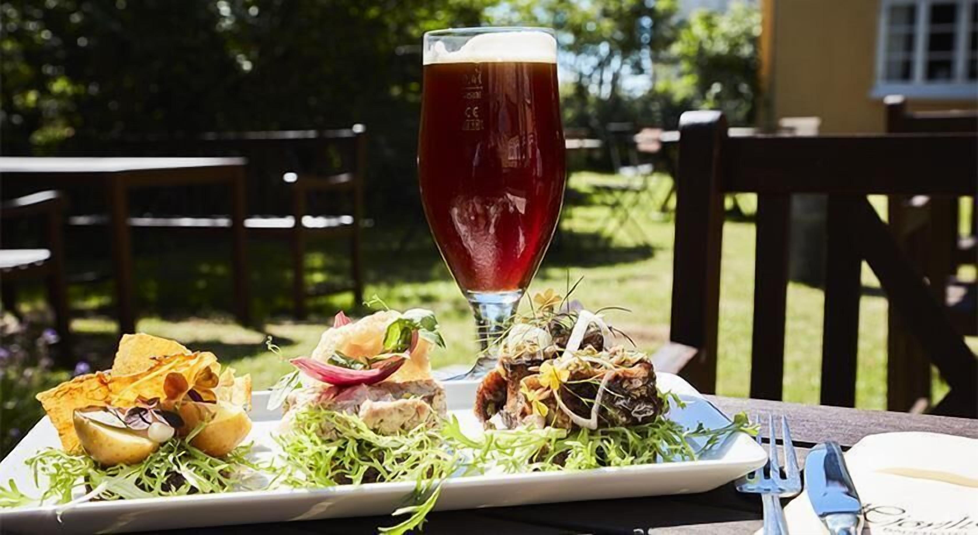 Comida con una cerveza en una mesa al aire libre.