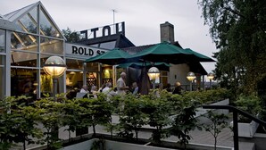 En restaurang som heter ROLD ST, med uteservering och en modern glasfasad.