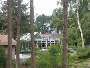 A building named 'Rold Storkro' surrounded by tall trees.