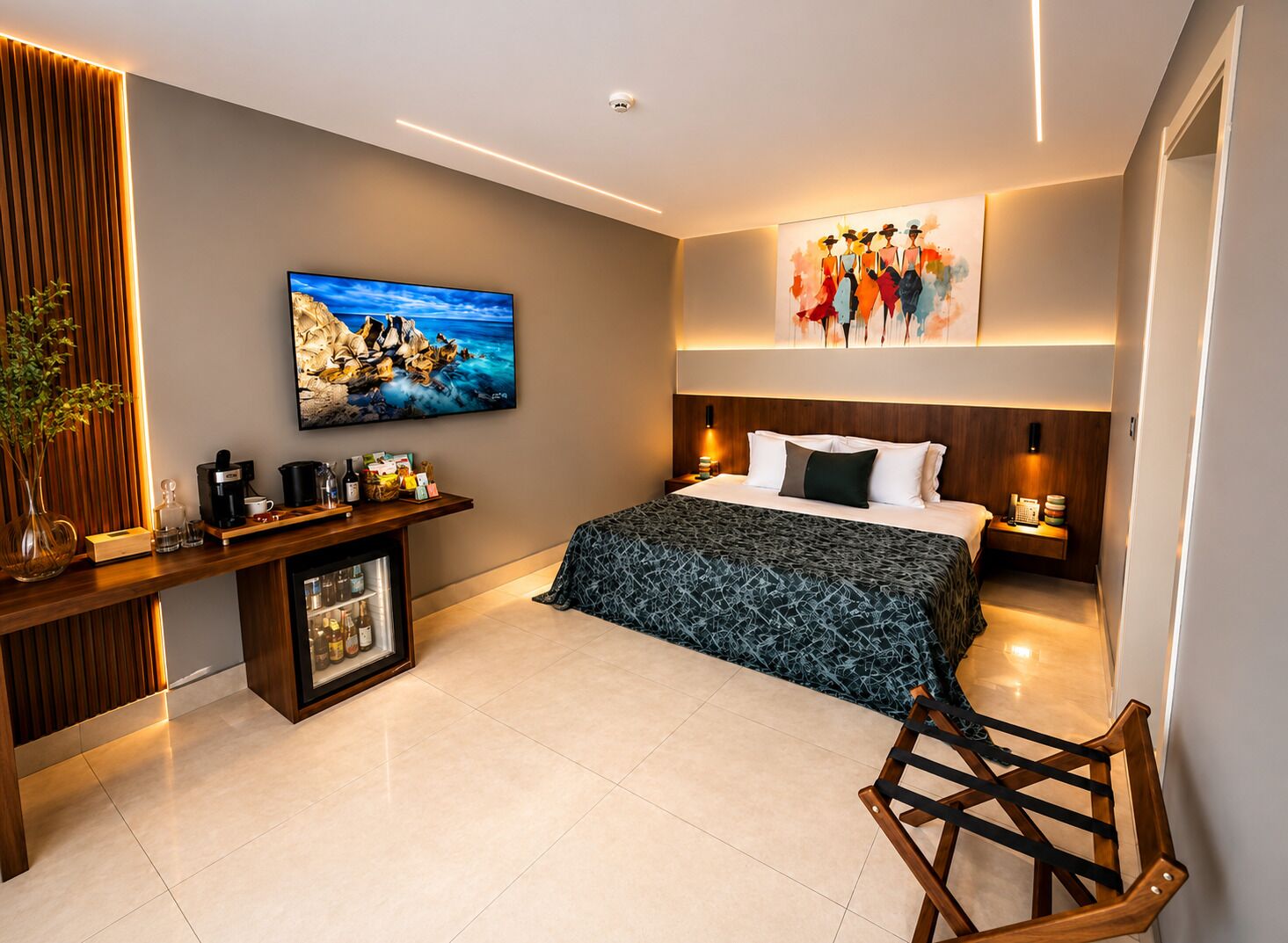 Una habitación de hotel moderna con cama, mesitas de noche, televisor, obras de arte y minibar.